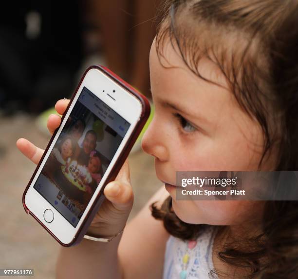 Luciana holds up a phone at a news conference with a picture of her father, Pablo Villavicencio, an immigrant deliveryman who was detained by...