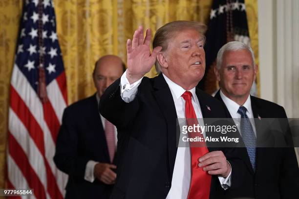 President Donald Trump waves as Vice President Mike Pence and Secretary of Commerce Wilbur Ross look on during a meeting of the National Space...