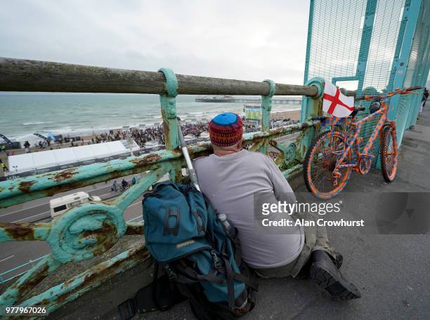 Football fan watches the match from the promenade on Brighton beach as England play Tunisia in the group stages of the 2018 FIFA World Cup tournament...