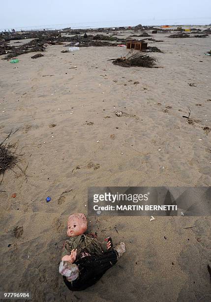 Doll is seen lying on the sand after a tsunami hit Penco, 10 kms from Concepcion, the day after a huge 8.8-magnitude earthquake rocked Chile early...