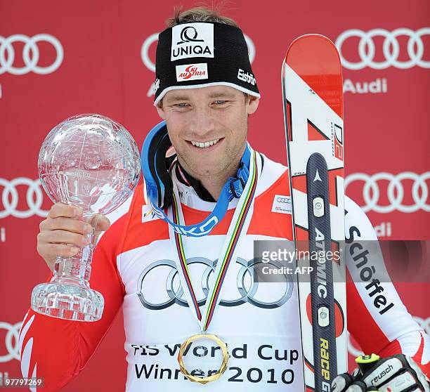 Overall combined winner Austria's Benjamin Raich poses with the globe in the finish area after the men's Alpine skiing World Cup Slalom finals in...