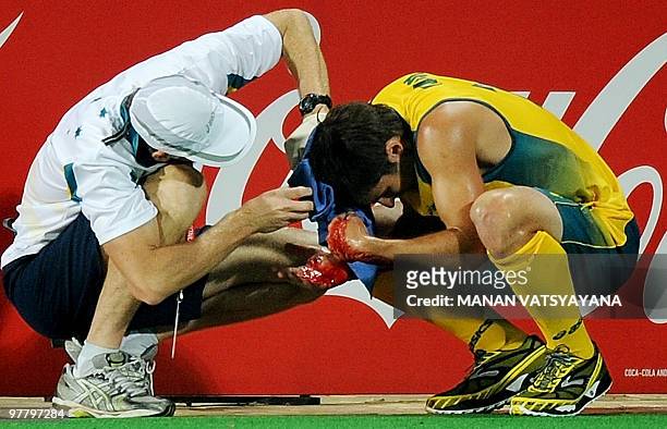 Australian Hockey player Kiel Brown is assisted by the team medic after getting injured during the World Cup 2010 Final match against Germany at the...