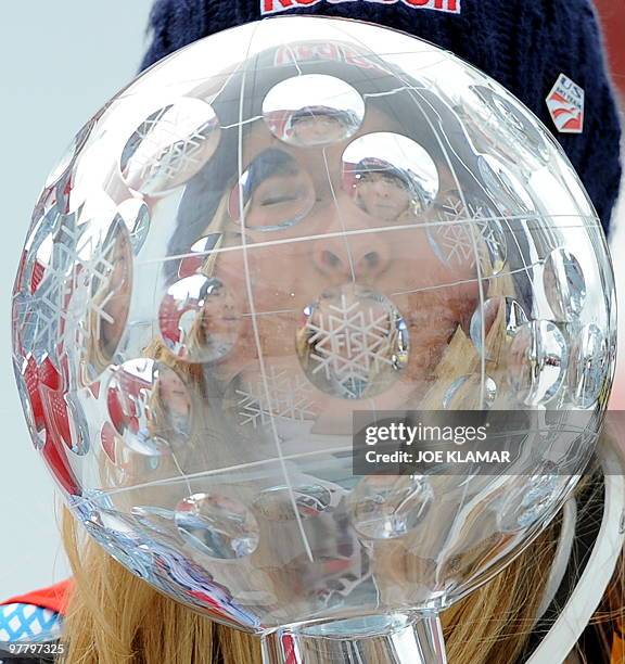 Overall world cup winner US Lindsey Vonn poses with the big globe in the finish area after the women's Alpine skiing World Cup Slalom finals in...