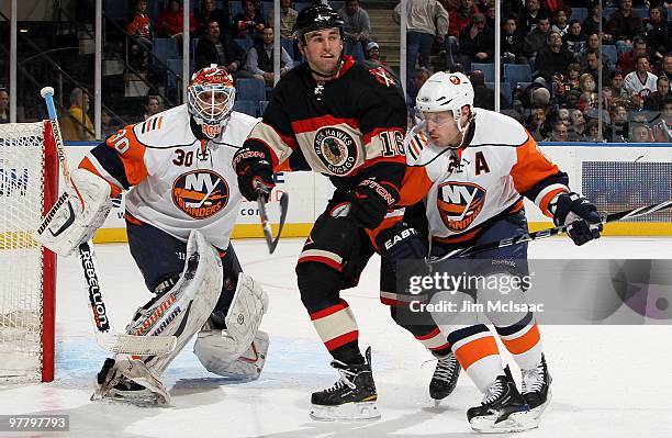 Andrew Ladd of the Chicago Blackhawks skates against Dwayne Roloson and Mark Streit of the New York Islanders on March 2, 2010 at Nassau Coliseum in...