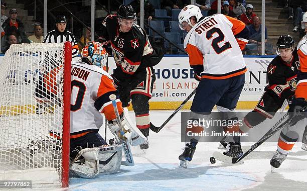Jonathan Toews of the Chicago Blackhawks skates against Mark Streit and Dwayne Roloson of the New York Islanders on March 2, 2010 at Nassau Coliseum...