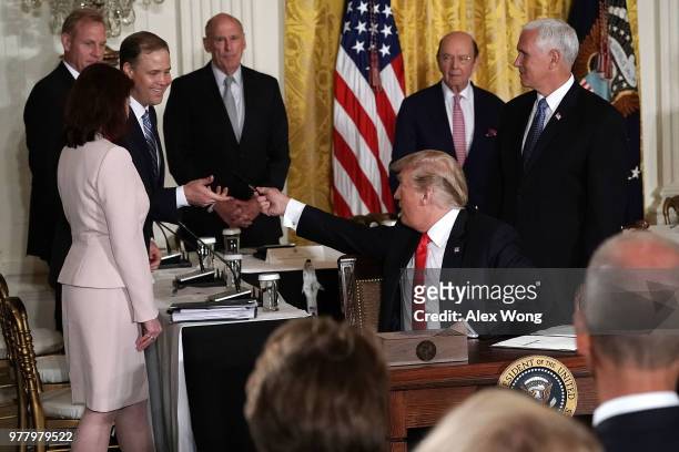 President Donald Trump gives the signing pen to NASA Administrator Jim Bridenstine after he signed an executive order during a meeting of the...