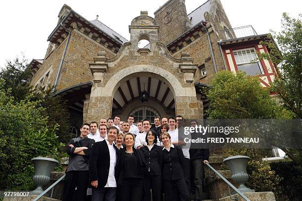 French chef Olivier Roellinger and his wife Jeanne poses with his staff on March 12 at the Chateau Richeux in Cancale, western France. His restaurant...