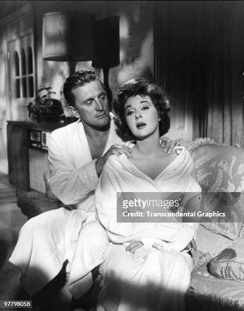 Film still of American actor Kirk Douglas he rubs the shoulders of actress Susan Hayward in a scene from 'Top Secret Affair' , 1957.