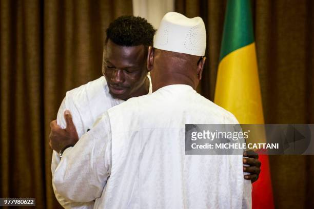 Mali's President Ibrahim Boubacar Keita embraces Malian immigrant in France turned hero, Mamoudou Gassama during their meeting on June 18, 2018 in...
