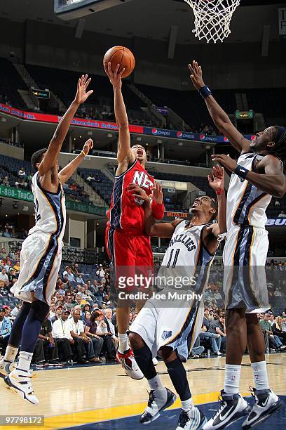 Devin Harris of the New Jersey Nets goes to the basket against Mike Conley and DeMarre Carroll of the Memphis Grizzlies during the game on March 8,...
