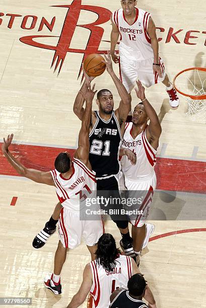 Tim Duncan of the San Antonio Spurs goes up for a shot against Shane Battier, Chuck Hayes, Luis Scola of the Houston Rockets during the game at...