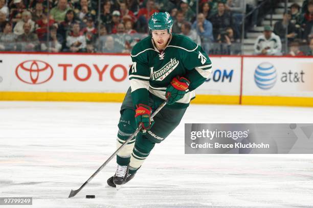 Kyle Brodziak of the Minnesota Wild skates with the puck against the St. Louis Blues during the game at the Xcel Energy Center on March 14, 2010 in...