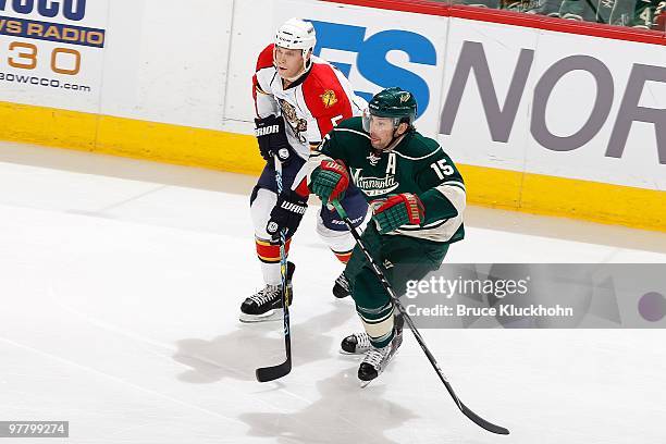 Andrew Brunette of the Minnesota Wild and Bryan Allen of the Florida Panthers skate to the puck during the game at the Xcel Energy Center on March 9,...