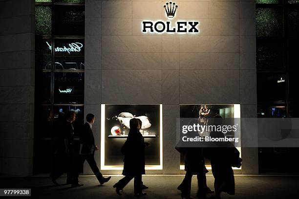 Visitors look at watches at the Rolex stand at the Baselworld watch fair in Basel, Switzerland, on Wednesday, March 17, 2010. The Baselworld Watch...