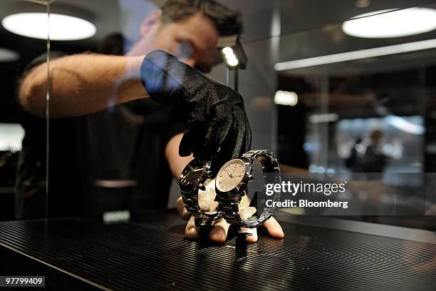 An employee cleans a watch at the Rado stand at the Baselworld watch fair in Basel, Switzerland, on Wednesday, March 17, 2010. The Baselworld Watch...