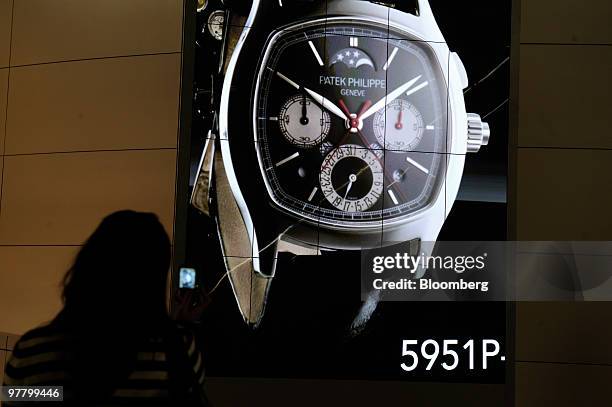 Visitor takes a picture at the Patek Philippe stand at the Baselworld watch fair in Basel, Switzerland, on Wednesday, March 17, 2010. The Baselworld...