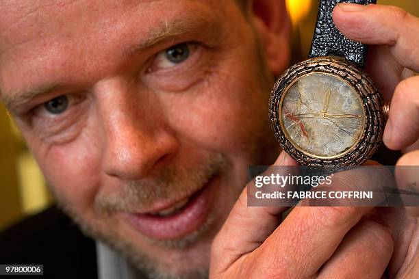 Artya CEO Swiss designer Yvan Arpa poses with his last creation, a 'dinosaur dung watch' during the press preview day at the Baselworld 2010 watch...