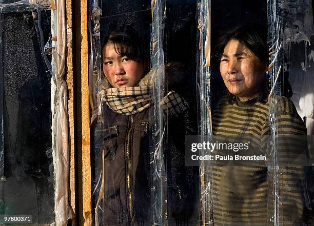 Erdnee stands along side her daughter Otgontuya looking out from their small home after moving from Tuv province in search of a better life on March...
