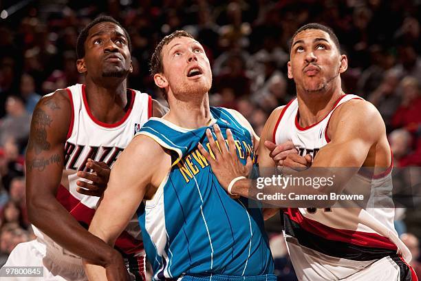 Martell Webster and Jeff Pendergraph of the Portland Trail Blazers battle for position with Darius Songaila of the New Orleans Hornets during the...