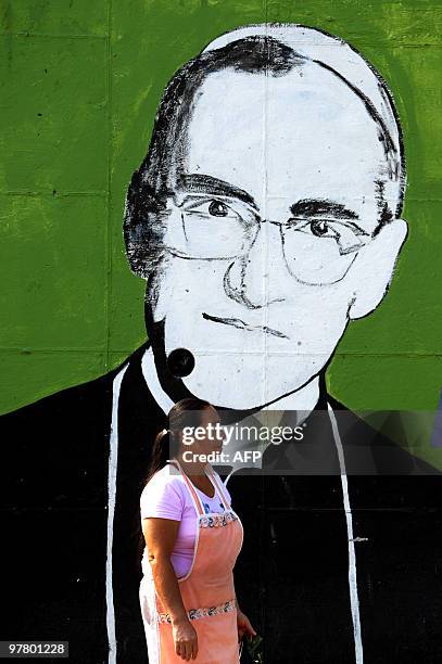 Woman passes by a mural depicting the portrait of Mons. Oscar Arnulfo Romero at La Divina Providencia Hospital in San Salvador on March 17 ahead of...