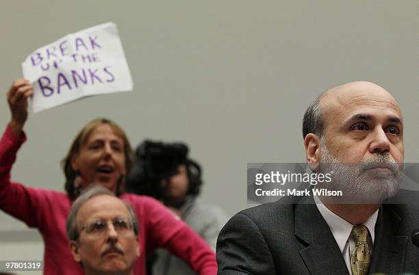Code Pink member Medea Benjamin holds up a sign while Federal Reserve Board Chairman Ben Bernanke testifies during a House Financial Services...