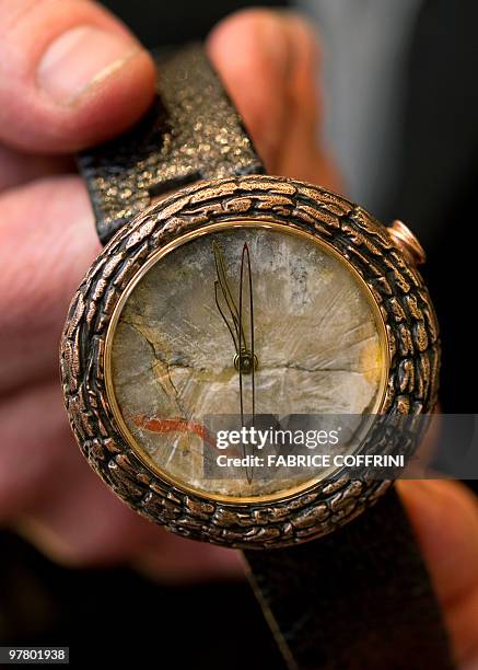 Artya CEO Swiss designer Yvan Arpa's holds his last creation, a 'dinosaur dung watch' during the press preview day at the Baselworld watch and...