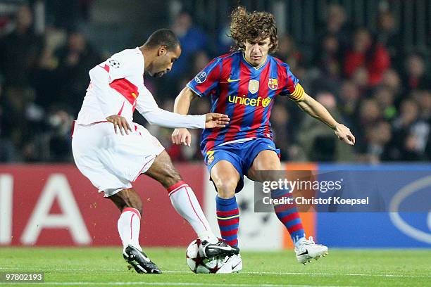 Carles Puyol of Barcelona challenges Cacau of Stuttgart during the UEFA Champions League round of sixteen second leg match between FC Barcelona and...