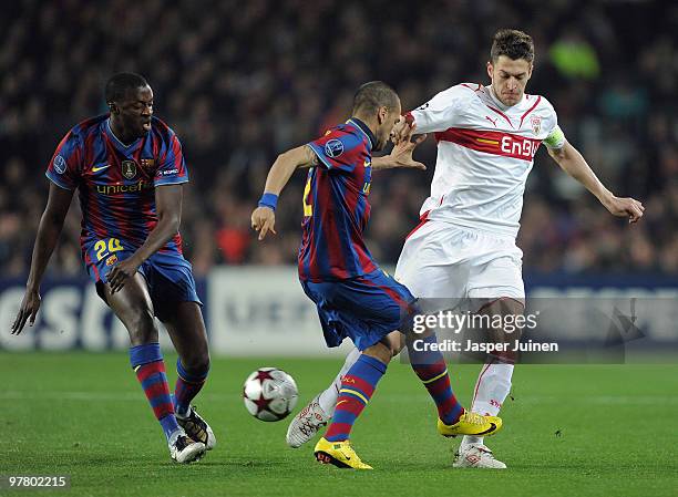 Matthieu Delpierre of Stuttgart duels for the ball with Daniel Alves and Yaya Toure of FC Barcelona during the UEFA Champions League round of sixteen...
