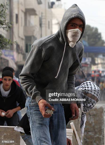 Palestinian youths hurl stones at Israeli soldiers during clashes on March 17, 2010 in the West Bank refugee camp of Qalandia. Tensions over...