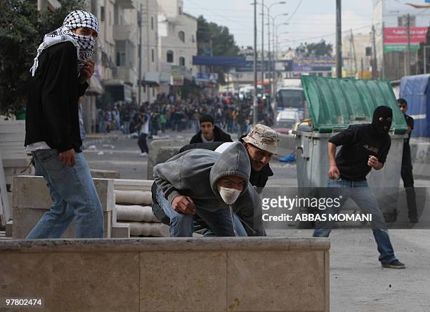 Palestinian youths hurl stones at Israeli soldiers during clashes on March 17, 2010 in the West Bank refugee camp of Qalandia. Tensions over...