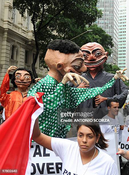 Demonstrators carry papier mache dolls during the "Against Cowardice-In Defence of Rio" protest against the cut in oil tax revenues to be voted by...