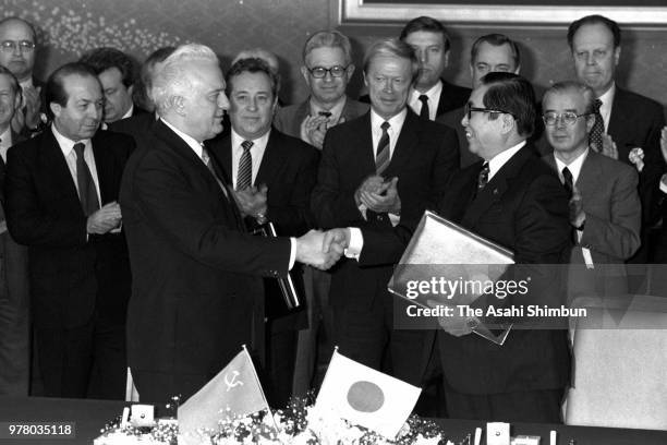 Soviet Union Foreign Minister Eduard Shevardnadze and Japanese Foreign Minister Sosuke Uno shake hands after exchanging signed documents following...