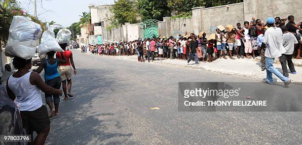 Quake victims take part to a food distribution on March 17 2010 in Petion-ville, Haiti. Haiti has unveiled the first draft of its grand...