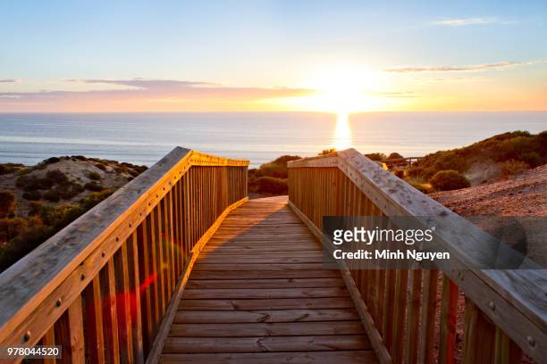 footbridge and sunrise, over sea, adelaide, south australia, australia - bay adelaide stock pictures, royalty-free photos & images
