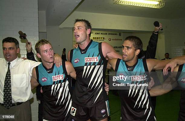 Port Adelaide players, with coach Mark Williams, l, sing the club song after the match between the Brisbane Lions and Port Power in round 1 of the...