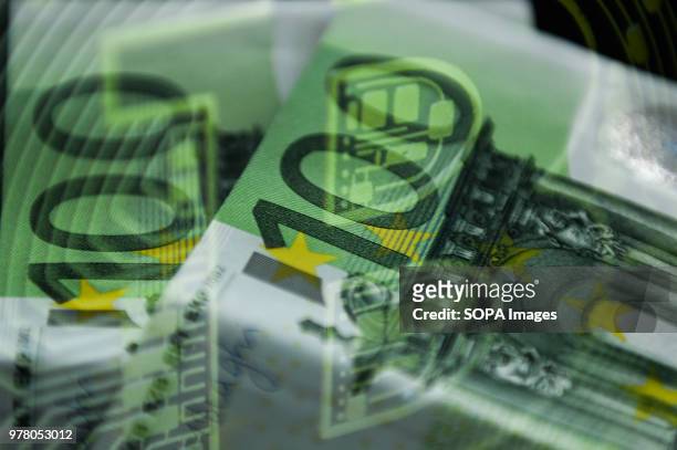 In this photo illustration a double exposure picture with a bitcoin and one hundred euros banknote.