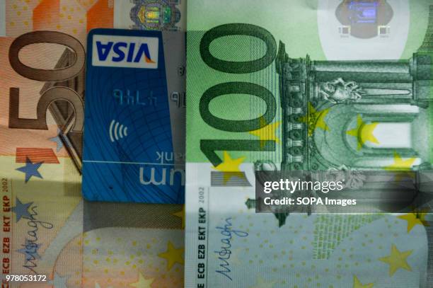 One hundred, fifty euros banknotes and VISA card are seen in this photo illustration.