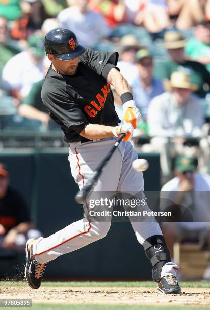 Mark DeRosa of the San Francisco Giants bats against the Oakland Athletics during the MLB spring training game at Phoenix Municipal Stadium on March...