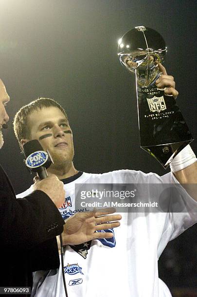 Tom Brady holds the Vince Lombardi Trophy as he stands on the podium after The New England Patriots defeated The Philadelphia Eagles in Super Bowl...