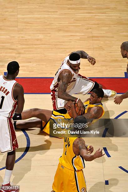 LeBron James of the Cleveland Cavaliers reaches in for the ball from fallen Solomon Jones of the Indiana Pacers on March 17, 2010 at The Quicken...