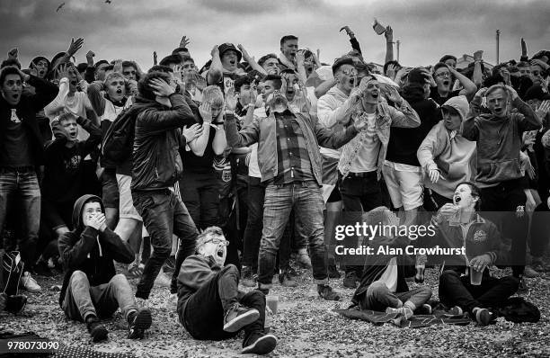 Football fans react as England go close to scoring as they watch the match inside the Lunar Beach Cinema on Brighton beach as England play Tunisia in...