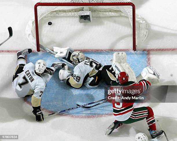 Marc-Andre Fleury and Mark Eaton of the Pittsburgh Penguins cannot stop a goal by Zach Parise of the New Jersey Devils during the game at the...