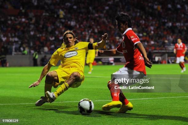 Toluca's player Nestor Calderon vies for the ball with Frankie Hejduk of Columbus during their match as part of the 2010 Concachampions Tournament at...
