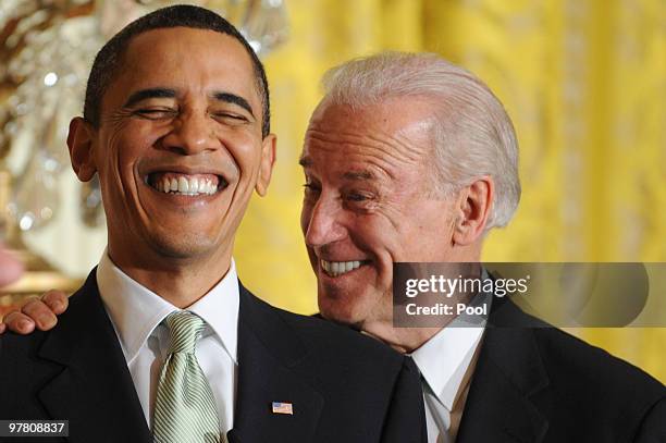 President Barack Obama and Vice President Joe Biden laugh during the annual St. Patrick's Day Reception in the East Room of the White House, March...