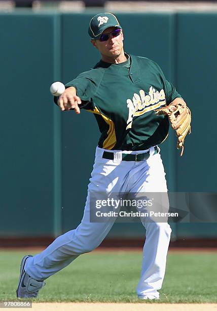 Infielder Mark Ellis of the Oakland Athletics fields a ground ball out against the San Francisco Giants during the MLB spring training game at...