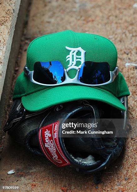 Detroit Tigers baseball glove and green hat to honor St. Patricks Day sit in the dugout during the spring training game against the Pittsburgh...