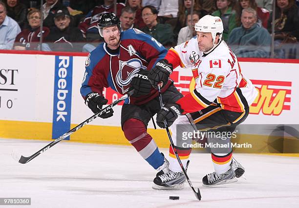 Daymond Langkow of the Calgary Flames passes against Milan Hejduk of the Colorado Avalanche at the Pepsi Center on March 17, 2010 in Denver,...