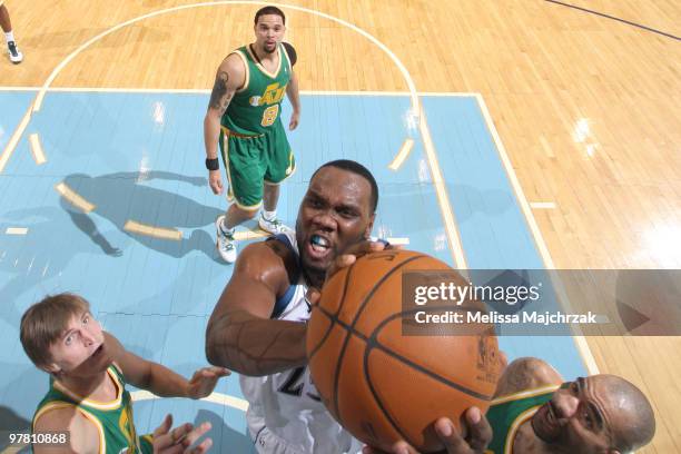 Al Jefferson of the Minnesota Timberwolves goes up for the dunk against Carlos Boozer and Andrei Kirilenko of the Utah Jazz at EnergySolutions Arena...