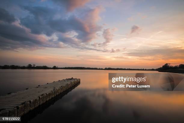 calm lake and jetty during sunset, lummen, limburg, belgium - lummen stock pictures, royalty-free photos & images