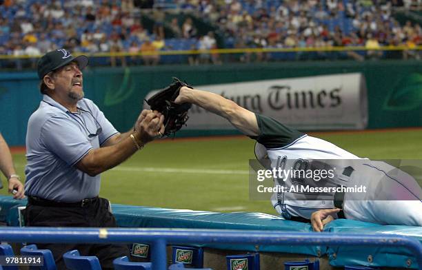 Tampa Bay Devil Rays fan tangles with third baseman Nick Green over a foul ball during play against the Oakland Athletics April 10, 2005 at Tropicana...